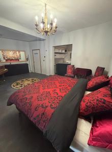 1 dormitorio con 1 cama grande de color rojo y lámpara de araña en Masquerade Suite, en Brujas 5 fotos más