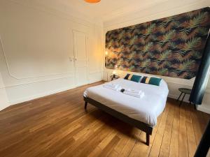 ランスにあるHincmar super suite en hyper centre cathédraleの壁に大きな絵が飾られたベッドのある寝室