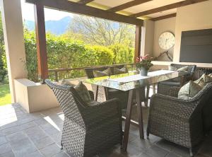 a patio with a table and chairs and a clock at 10onErika Franschhoek in Franschhoek