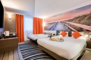 una habitación de hotel con 2 camas y una pintura en Novotel Paris Centre Bercy, en París