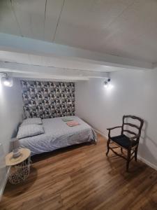 a bedroom with a bed and a chair and a table at L Escale Esnandaise in Esnandes