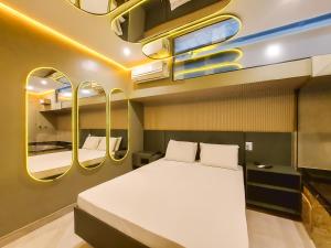 a bedroom with a large white bed and some mirrors at Motel Gaia Radial Leste in Sao Paulo