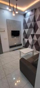 Una sala de estar con un sofá y un televisor en una pared. en Business Stay, en Māripat