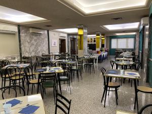an empty dining room with tables and chairs at Albergo Regina Mundi in Pietra Ligure +27 photos