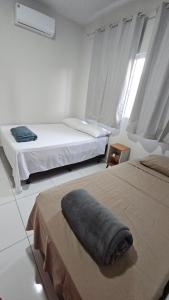 a bedroom with two beds and a pillow on the bed at Casa Coqueiro in Primavera do Leste
