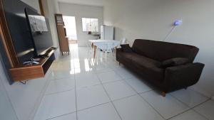 a living room with a couch and a table at Casa Coqueiro in Primavera do Leste
