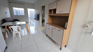 a kitchen and living room with a table and chairs at Casa Coqueiro in Primavera do Leste