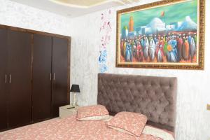 メクネスにあるMeknès 3 Spacious Penthouseのベッドと壁に絵が飾られた寝室 +16枚の写真