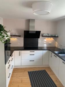a kitchen with white cabinets and a black counter top at Auszeit Deluxe in Kirchheim unter Teck +17 photos