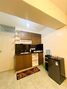 a kitchen with wooden cabinets and a black refrigerator at Elegant One bedroom in Kiambu