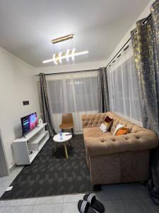a living room with a couch and a tv at Elegant One bedroom in Kiambu