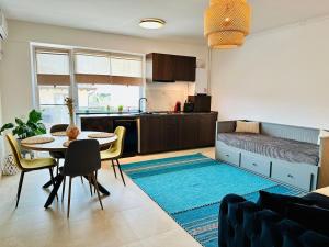 a living room with a table and a kitchen at Caro Studio in Tunari