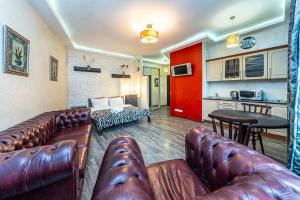 a living room with leather furniture and a kitchen at Уютная квартира с джакузи в центре Киева in Kyiv +10 photos