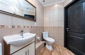 a bathroom with a sink and a toilet and a mirror at Уютная квартира с джакузи в центре Киева in Kyiv