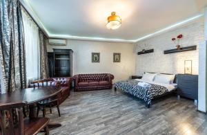 a living room with a bed and a couch and a table at Уютная квартира с джакузи в центре Киева in Kyiv