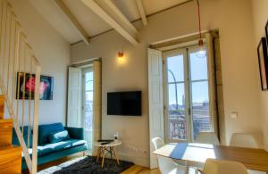 ein Wohnzimmer mit einem blauen Sofa und einem Tisch in der Unterkunft Porto Cinema Apartments in Porto