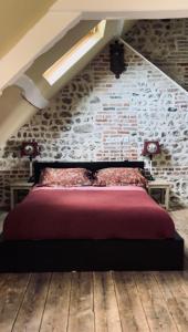 a bed in a room with a brick wall at La Petite Maison in Honfleur