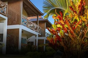 Un edificio con un montón de plantas delante. en Java Bangalôs, en Imbituba