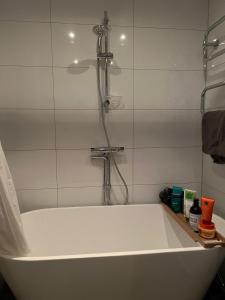 a white bath tub with a shower in a bathroom at Casa Hylle in Löddeköpinge