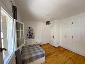 a bedroom with a bed and white walls and wooden floors at Villa Maadi 35 -R 303 -Double Room in Cairo +18 photos