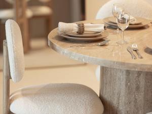a table with chairs and a table with plates and wine glasses at Grande Signature Residences by Prestige Nest in Dubai +80 photos