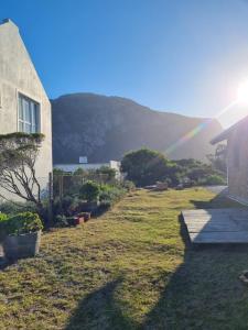 a rainbow in the sky over a yard with a house at Heaven Scent in Bettyʼs Bay +3 photos