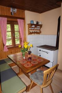 a kitchen with a table with a vase of flowers on it at Almhütte Groß Frondell in Kötschach +17 photos
