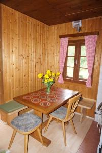 a wooden table with a vase of flowers on it at Almhütte Groß Frondell in Kötschach