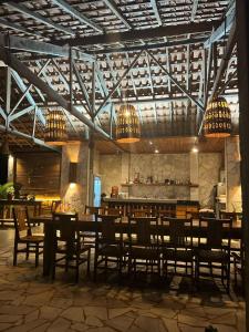 a restaurant with wooden tables and chairs and chandeliers at Pousada do Dione in Delfinópolis