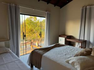 a bedroom with a bed and a sliding glass door at Pousada do Dione in Delfinópolis