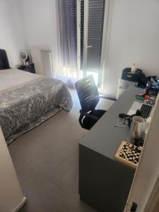 ein Schlafzimmer mit einem Bett und einem Schreibtisch mit einem Computer in der Unterkunft Appartement partagé in Méry-sur-Oise + 9 Fotos