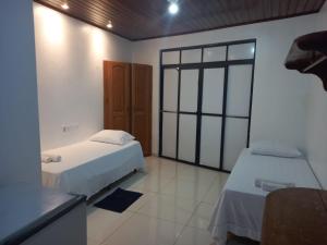 a bedroom with two beds and a window at Pousada Cop 30 in Belém