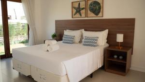 a bedroom with a large white bed with pillows at Villa Moderna in Trairi