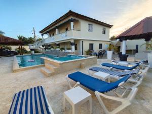 a group of chairs and a swimming pool in front of a house at Elegant 7BRVilla in Cabarete, Whirlpool, Pool, Beach, Adventure! in Cabarete