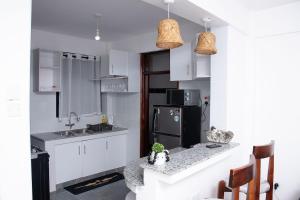 BusiaにあるKayla Suites-2 Bedroom Apartmentの白いキャビネットと黒い冷蔵庫のあるキッチン