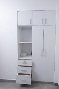 BusiaにあるKayla Suites-2 Bedroom Apartmentの白いクローゼット(白いキャビネットと引き出し付)