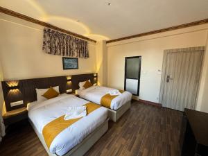 a hotel room with two beds and a television at Evara Hotel & Apartment in Kathmandu +24 photos