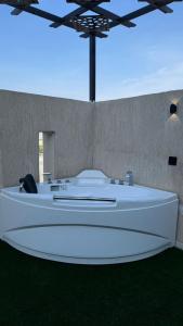 a room with a large white table with green grass at شاليه الهنا in Jeddah