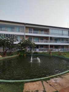 a building with a pond in front of a building at Apartamento boa vida in Aquiraz