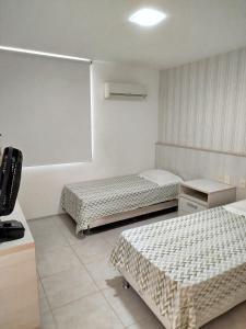 a room with two beds and a tv in it at Apartamento boa vida in Aquiraz +16 photos