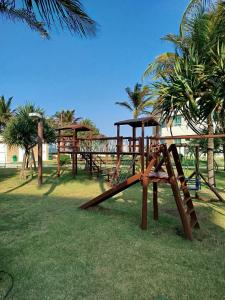 a park with a wooden playground with a slide at Apartamento boa vida in Aquiraz