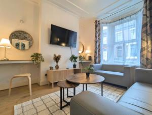 a living room with a couch and a table at Bright 4br Home Near Anfield & Free Parking in Liverpool +13 photos