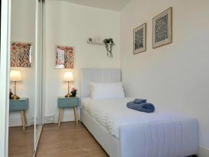 a bedroom with a white bed with a towel on it at Bright 4br Home Near Anfield & Free Parking in Liverpool