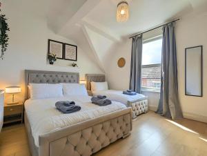 a bedroom with two beds and a large window at Bright 4br Home Near Anfield & Free Parking in Liverpool