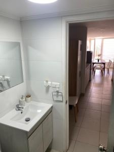 a white bathroom with a sink and a mirror at Vista Abanico in Maitencillo +68 photos