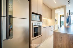 a kitchen with a stainless steel refrigerator and a counter at Apto c/ varanda e churrasqueira em Jurerê IHD0101 in Florianópolis
