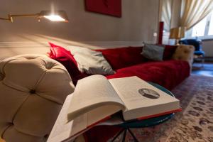 an open book on a table next to a couch at Domus Tua in Modena