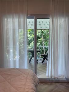 a bedroom with a bed and a large glass window at Simple Cozy House Coconut Lane in Hinkong
