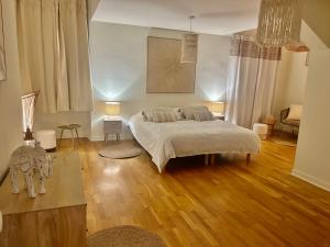 a bedroom with a bed in a room with wooden floors at Logis de Russay in Saivres