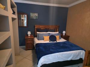 een slaapkamer met een groot bed met blauwe muren bij The Pot in Pretoria